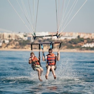 a man holding a kite while standing in a body of water